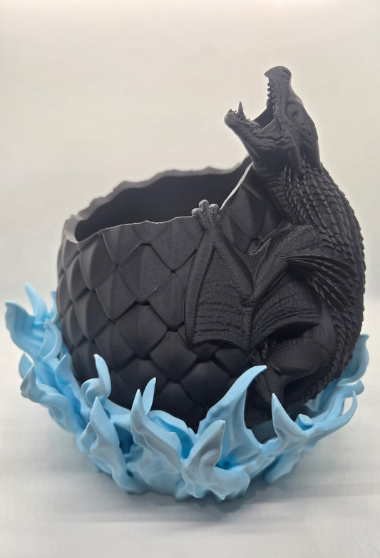 "3D printed dragon egg planter with flame base"

"Fantasy-themed plant pot with dragon coiled around egg"

"Dragon egg flower pot – black egg and red flames"